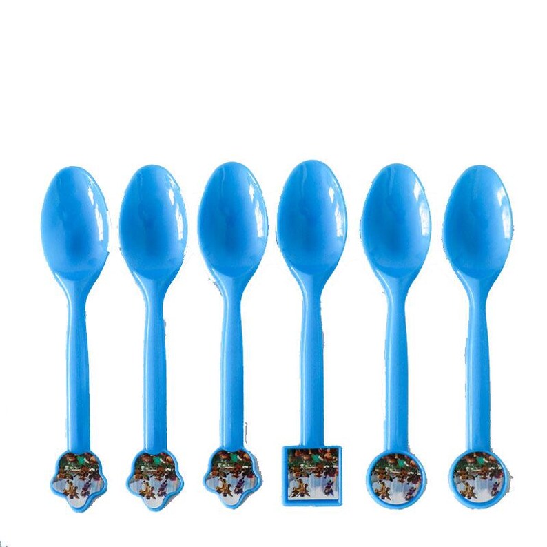 Puede incluir: Seis cucharas de pl&aacute;stico azul con bases decorativas. Las cucharas tienen cuencos ovalados y mangos largos y delgados. Las bases presentan ilustraciones coloridas. Las cucharas est&aacute;n dispuestas en fila sobre un fondo blanco.