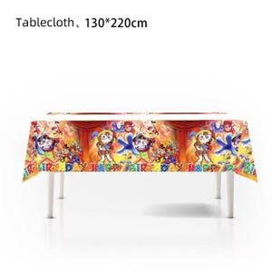 May include: A colorful birthday-themed tablecloth, measuring 51x87 inches, is draped over a white table. The design features cartoon characters, the words "HAPPY BIRTHDAY," and a red curtain backdrop. The tablecloth is vibrant with yellow, blue, and red hues.