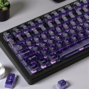 Puede incluir: Un teclado mecánico negro con teclas moradas transparentes. Las teclas están retroiluminadas con un brillo púrpura. El teclado tiene un diseño compacto con teclas de función y una tecla Shift.
