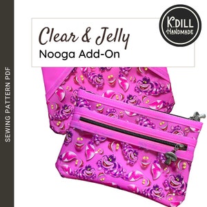 Puede incluir: Una bolsa rosa con cremallera, con un frente de vinilo transparente y un patrón repetido de un gato morado con una sonrisa de gato de Cheshire. La bolsa tiene dos cremalleras y un tirador de cremallera a rayas rosa y blancas. La bolsa está etiquetada como "Clear & Jelly Nooga Add-On".
