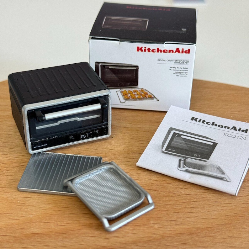 以下が含まれることがあります： エアフライ機能を備えた、ミニチュアのKitchenAidデジタルカウンタートップオーブン。 黒いオーブンはシルバーのハンドルとデジタルディスプレイを備えています。付属品には、シルバーのベーキングトレイとマニュアルが含まれます。 オーブンはオリジナルのパッケージで表示されています。