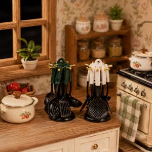 May include: A miniature kitchen scene with two sets of black cooking utensils, one with green handles and the other with white. A small white pot with a floral design and a miniature stove are also visible.