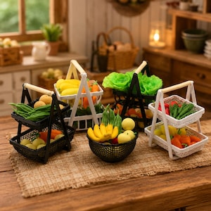 May include: A collection of miniature plastic produce baskets and a bowl filled with small-scale artificial fruits and vegetables, including yellow bananas, green okra, orange carrots, and leafy greens, arranged on a textured woven surface.