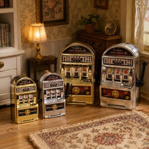 May include: Four miniature slot machines with metallic gold and silver finishes. Each machine features a curved top, a side lever, three spinning reels, and a front panel displaying the text Lucky slot machine and a yellow smiley face graphic.