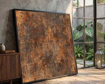 May include: Large framed artwork with a textured, rust-colored abstract design. The artwork is leaning against a wall in a room with a wooden floor, a wooden cabinet, and a large window with a view of greenery.