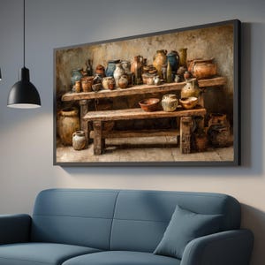 Puede incluir: Una obra de arte enmarcada que representa una colección de cerámica expuesta sobre mesas de madera rústicas. La cerámica incluye varios jarrones, vasijas y cuencos en tonos terrosos de marrón, beige y azul. La obra se exhibe sobre un sofá azul.