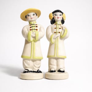 Juego de salero y pimentero de pareja asiática china de estilo Hollywood Regency de mediados de siglo (1940-50), vestidos de blanco, de pie - ¡en excelente estado!