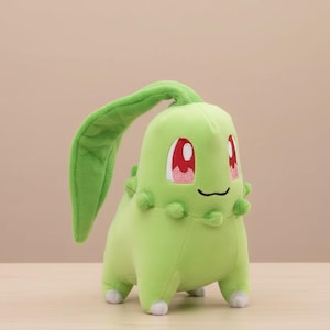 May include: A plush Chikorita toy in a light green color with a large leaf on its head. The toy has red eyes with white accents and a small, smiling mouth. The toy is approximately 6 inches tall.