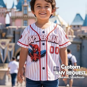 May include: A white and red pinstripe baseball jersey with "SPIDER-MAN" printed across the chest. The jersey features a Spider-Man graphic and the number "00". The text "Custom ANY REQUEST Amorina Handmade" is also visible.