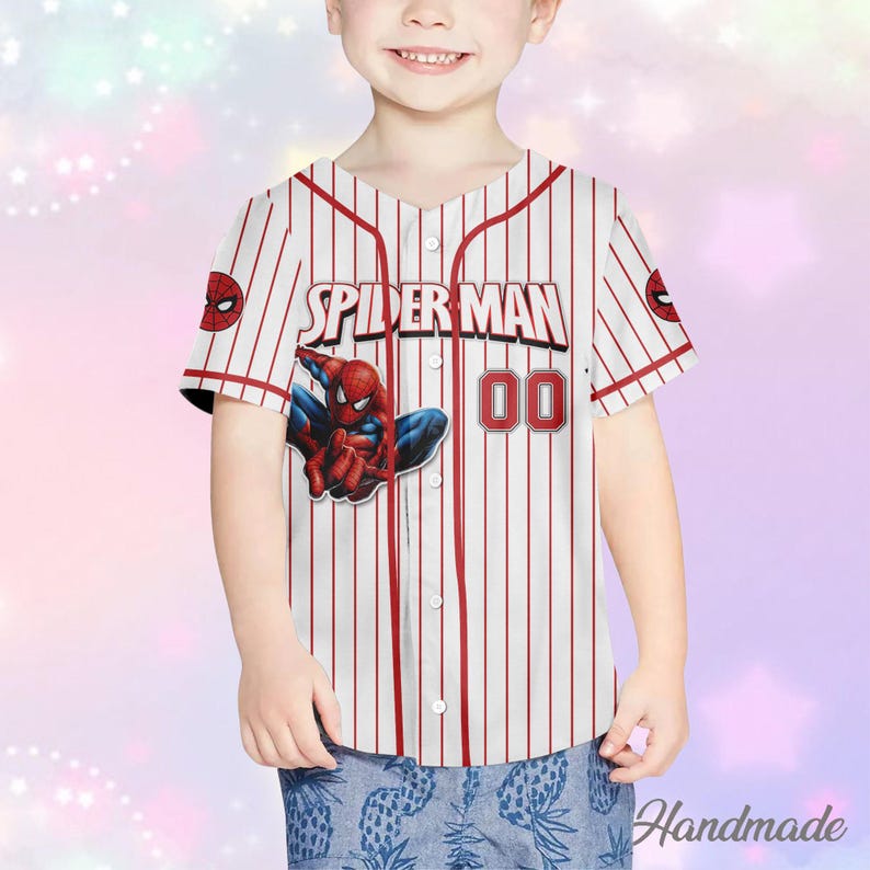 May include: White and red striped baseball jersey featuring the words "SPIDER MAN" and the number "00" in red. The jersey has a Spider-Man graphic on the front. The jersey has short sleeves and a button-up front.