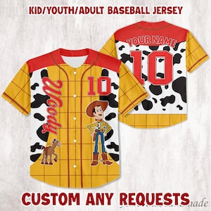 May include: Baseball jersey with a Woody design. The jersey is yellow with a red collar and sleeves. The front features the number 10, the name "Woody", and an image of Woody and a horse. The back has the number 10 and a cow print.