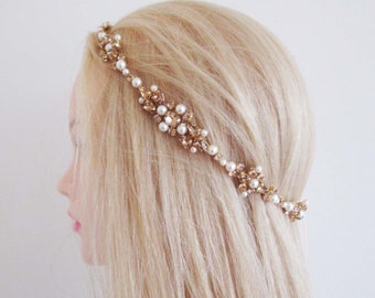 May include: A gold and pearl hair crown with a delicate design. The crown is made of small gold beads and pearls, and it is perfect for a wedding or other special occasion.