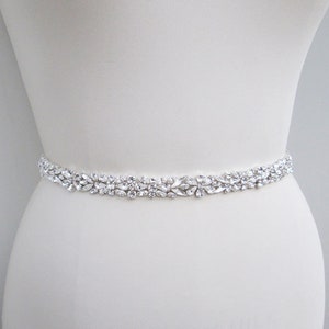 May include: A silver bridal belt with a row of clear crystal embellishments.
