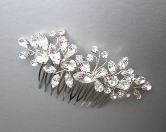 Puede incluir: Peine de pelo plateado con un diseño floral hecho de diamantes de imitación transparentes.