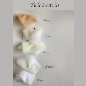 Op de afbeelding: Tule stof kleur stalen in Nude, Ecru, Ivory, Off White en Wit, elk vastgemaakt op een wit oppervlak. De tekst "Tulle Swatches" staat bovenaan. Ideaal voor bruids- of knutselprojecten.