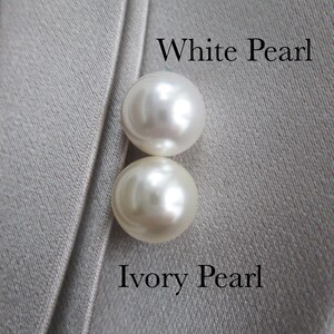 May include: Two round pearls, one white and one ivory, on a gray fabric background. The text "White Pearl" is above the white pearl and the text "Ivory Pearl" is below the ivory pearl.
