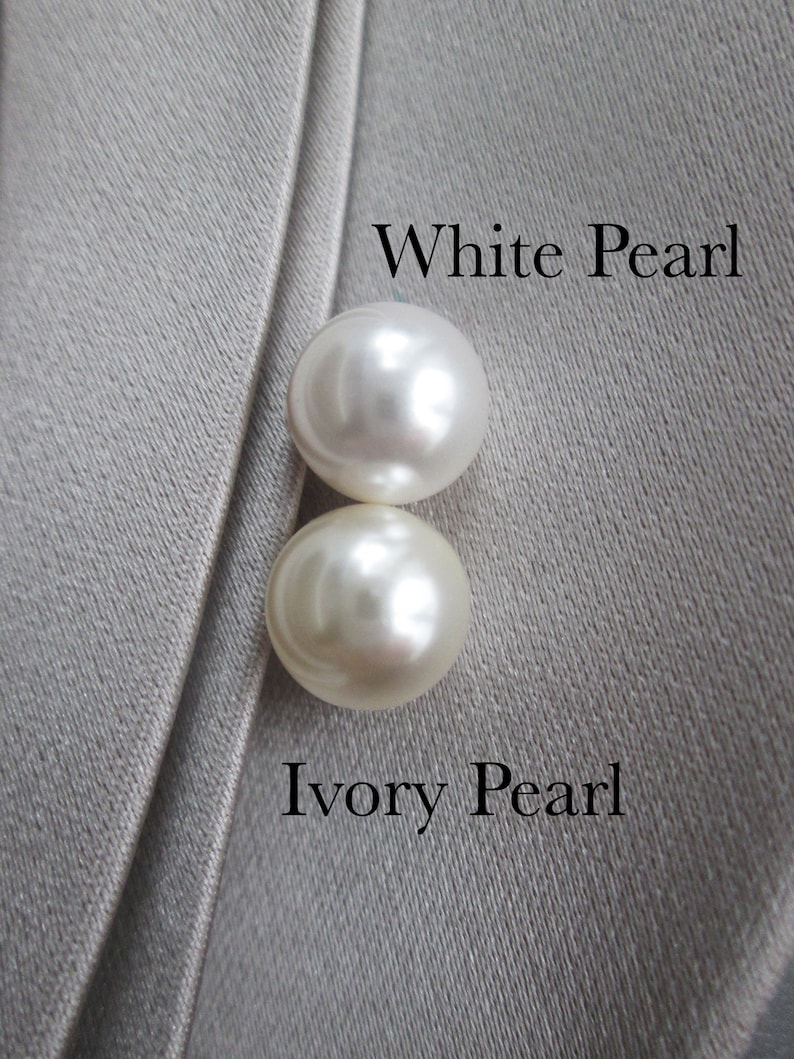May include: Two round pearls, one white and one ivory, on a gray fabric background. The text "White Pearl" is above the white pearl and the text "Ivory Pearl" is below the ivory pearl.