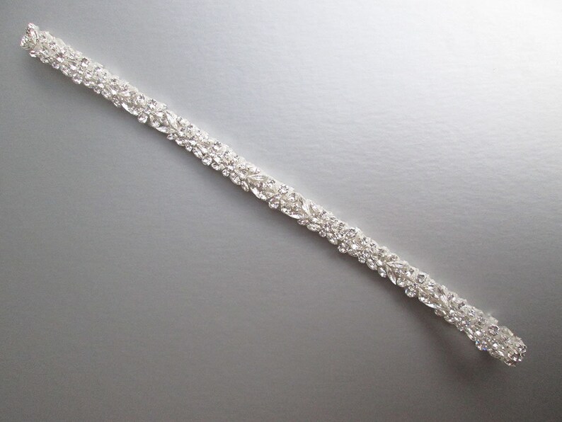 May include: A silver bridal sash with a row of clear rhinestones.
