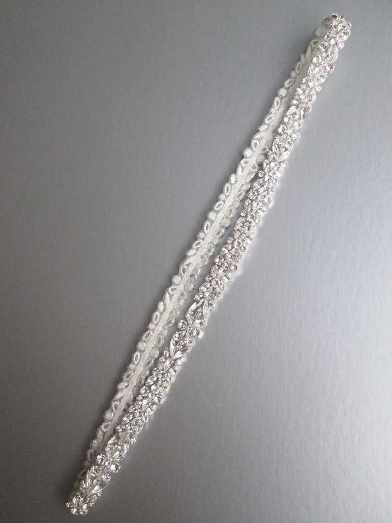 May include: A white satin bridal sash with a row of sparkling rhinestones.