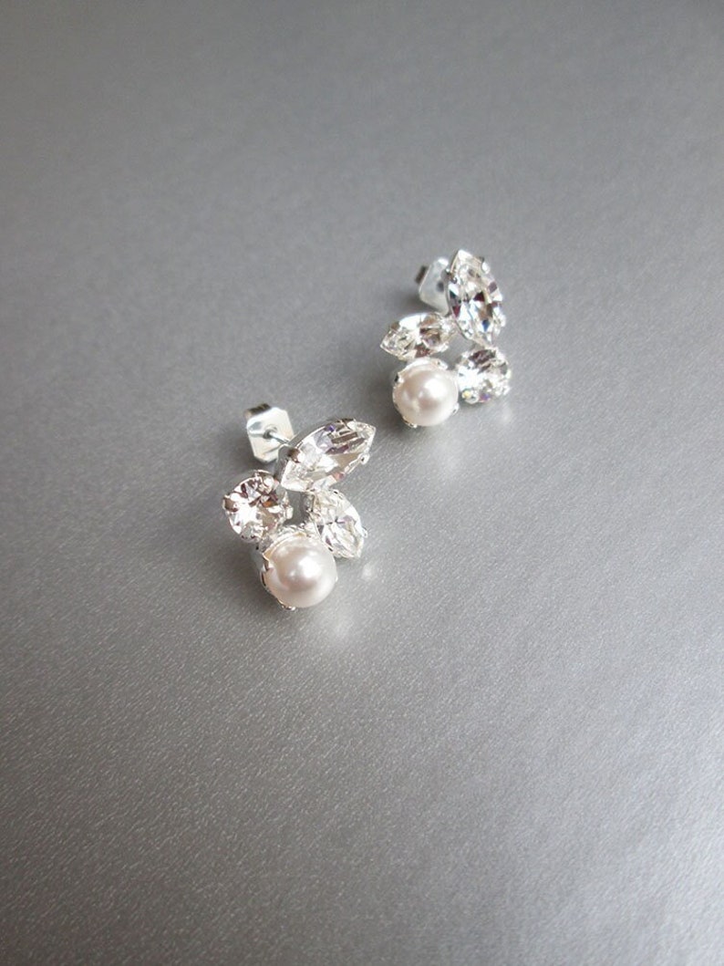 May include: A pair of silver earrings with a cluster of clear rhinestones and a single pearl on each earring.