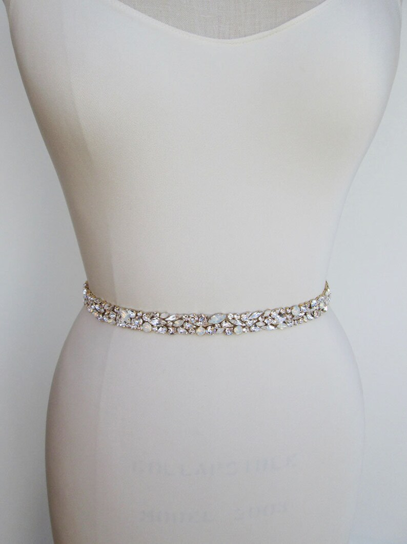 May include: A delicate bridal belt with a row of clear and iridescent crystals set in gold.