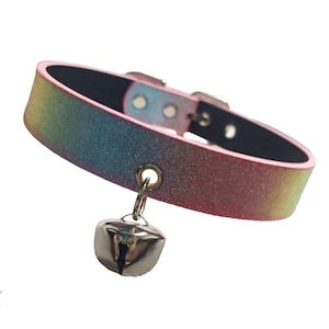 May include: A multi-coloured collar with a silver bell. The collar has a black interior and a buckle fastening. The bell hangs from a small ring attached to the collar. This is a fashion accessory.