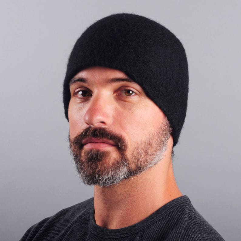 May include: A black beanie hat with a soft, fuzzy texture. The hat is worn by a person with a beard.