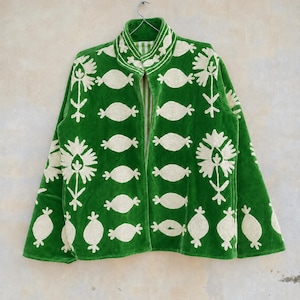 May include: A vibrant green jacket featuring an open front, a high collar, and long sleeves. The garment is decorated with cream-colored embroidered floral and oval-shaped motifs arranged in a repeating pattern across the entire surface.