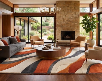 May include: A large area rug featuring a wavy, abstract pattern in shades of burnt orange, charcoal gray, and cream. The rug is positioned in a living room with a dark gray sofa, two tan armchairs, and a round wooden coffee table.
