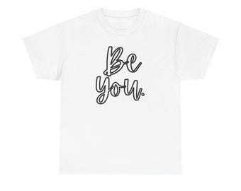 Op de afbeelding: Een wit T-shirt met de tekst "Be You" in een zwarte, handgeschreven lettertype. De tekst is gecentreerd op de voorkant. Het shirt heeft een ronde hals en korte mouwen.