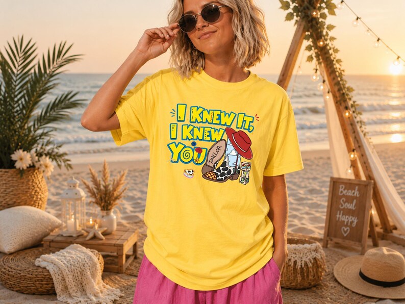 K&ouml;nnte beinhalten: Ein leuchtend gelbes T-Shirt mit dem Text I KNEW IT, I KNEW YOU in blauen und gelben Buchstaben. Die Grafik zeigt einen Cowboystiefel mit Kuhmuster, einen roten Hut, eine kleine Blume und einen Spielzeugblock. Das T-Shirt hat kurze &Auml;rmel.