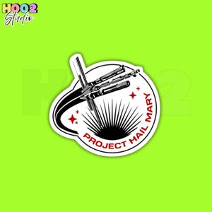 May include: A white sticker with a black and white spaceship design, the text "PROJECT MAIL MARY" in a circle, and red star accents. The sticker has a white border and is set against a bright green background.