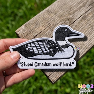 May include: Embroidered patch featuring a black and white loon bird design. The patch includes the text "Stupid Canadian wolf bird." The patch is on a white background with a black border.
