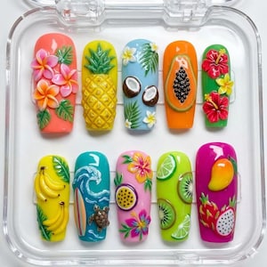 Peut inclure: Dix faux ongles décorés de motifs tropicaux colorés. Chaque ongle présente un design différent : ananas, papaye, noix de coco, fleurs d'hibiscus et kiwi. Les ongles sont présentés dans un étui en plastique transparent.