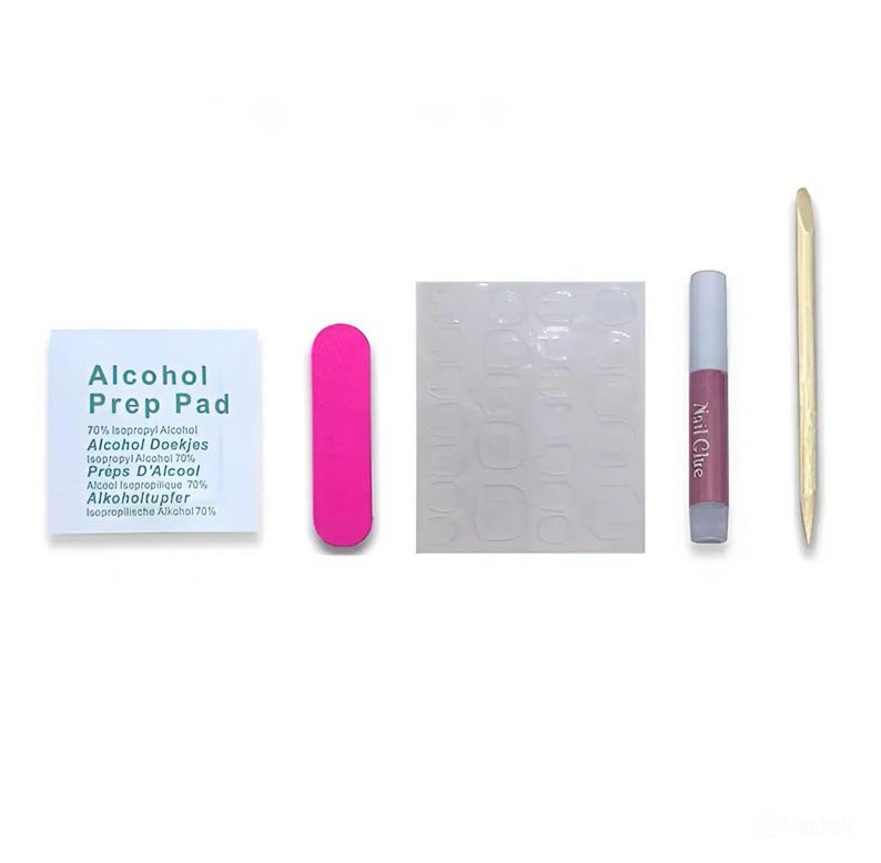 May include: A nail kit with an alcohol prep pad, a pink nail file, a sheet of adhesive nail tabs, a tube of nail glue, and a wooden cuticle pusher. The alcohol prep pad has the text "Alcohol Prep Pad" and other text in multiple languages.