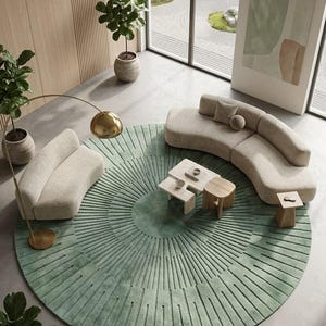 May include: A large circular sage green area rug featuring a radial sunburst pattern of carved lines. The rug is positioned under two curved beige sofas, a set of tiered light wood coffee tables, and a tall gold floor lamp with a dome shade.