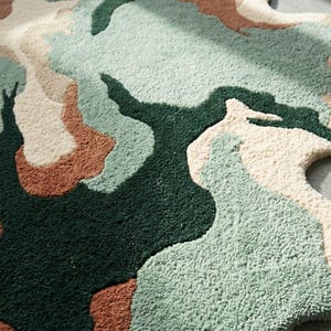May include: An area rug with an irregular, organic shape featuring a tufted texture. The design consists of abstract, flowing color blocks in deep forest green, sage green, cream, and terracotta orange, creating a layered, topographical appearance.