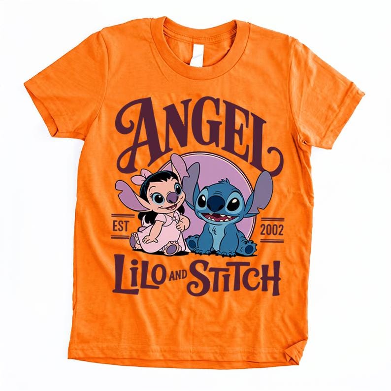May include: Bright orange t-shirt with a cartoon design of Angel and Stitch from Lilo and Stitch. The design includes the words "ANGEL" and "LILO AND STITCH" in a dark purple colour. The shirt also has the text "EST 2002".