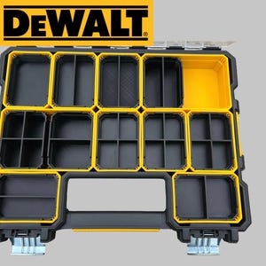 May include: A DeWalt brand organizer case featuring a black and yellow color scheme. The interior contains multiple removable storage bins of varying sizes, some with internal dividers, and two metal latches at the bottom for secure closure.