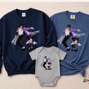 Puede incluir: Sudadera azul marino, camiseta azul y body gris con un gr&aacute;fico de Michael Jackson y Mickey Mouse. El dise&ntilde;o incluye el texto "Michael Jackson" y "Mickey Mouse". La camiseta tiene un dobladillo anudado.