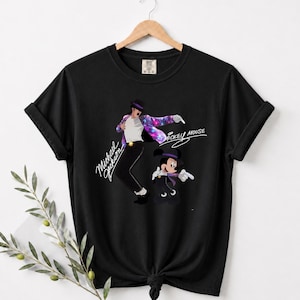 Unisex t-shirt, sweatshirt, hoodie, and baby bodysuit featuring a Michael Jackson and Mickey Mouse dancing graphic with galaxy jacket details and pop icon theme.