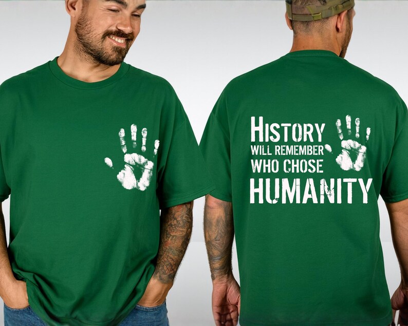 May include: Green t-shirt with a white handprint on the front and the text "History Will Remember Who Chose Humanity" on the back. The shirt is made of a soft material and is suitable for casual wear.