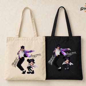 Puede incluir: Dos bolsas de mano, una beige y otra negra, cada una con un gr&aacute;fico de Michael Jackson y Mickey Mouse. Las bolsas tienen asas largas y el texto "Michael Jackson" y "Mickey Mouse" son visibles. Las bolsas tambi&eacute;n tienen el texto "Dreamify 34 Wear It".