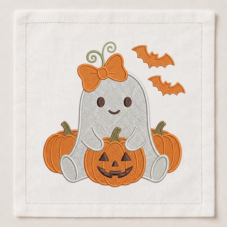 May include: A square white fabric napkin featuring an embroidered design of a light grey ghost with a large orange bow on its head, sitting between two plain orange pumpkins and holding a central orange jack-o'-lantern, with two orange bats.