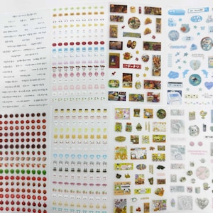 May include: A collection of adhesive sticker sheets featuring a variety of designs including small colorful fruit, vegetables, animals, food items, and text. The sheets contain rows of repeating icons, rectangular scenes, and circular graphics in various colors.