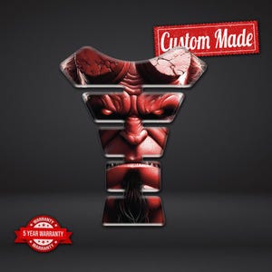 May include: A red, custom-made motorcycle tank protector with a stylized, demonic face design. The graphic features a detailed depiction of a face with a stern expression. A red banner with the text "Custom Made" is in the upper right corner.