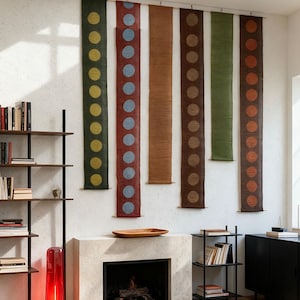 May include: Six vertical wall hangings with a repeating dot design. The hangings are in shades of green, red, brown, and orange. Each is approximately 152 cm long and 15 cm wide. The dots are in contrasting colours, creating a striking visual.