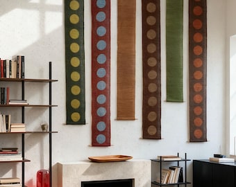 May include: Six vertical wall hangings with a repeating dot design. The hangings are in shades of green, red, brown, and orange. Each is approximately 152 cm long and 15 cm wide. The dots are in contrasting colours, creating a striking visual.