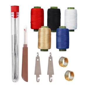 Può includere: Un kit da cucito composto da un tubo in plastica trasparente con aghi argentati, un taglia-asole marrone, cinque rocchetti di filo rosso, nero, bianco, beige e blu, due infila-aghi in metallo argentato e due ditali in metallo color oro.