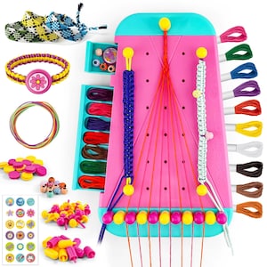 May include: A pink and teal bracelet-making kit with a variety of colorful threads, beads, and accessories. The kit includes a pink loom with yellow pegs, completed bracelets, and a drawer with small beads. The kit is designed for making friendship bracelets.